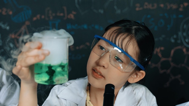 Foto jovem garota segurando solução química verde e inspecionar cuidadosamente edificação