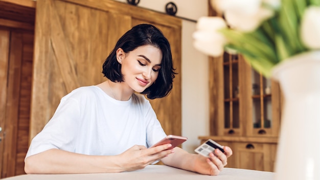 Jovem mulher com um telefone nas mãos dela