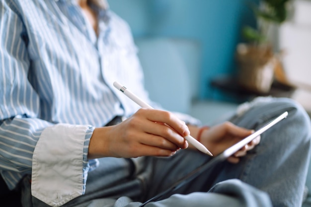 Jovem mulher usando tablet passando tempo de lazer conversando na rede social