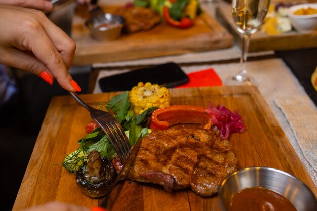 Foto junge frau, die im restaurant gegrilltes steak isst?