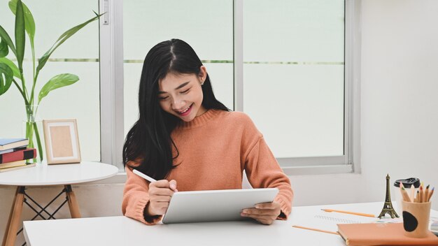 Foto junge kreative asiatische frau, die tablette und stift im grafikdesignerarbeitsplatz verwendet.