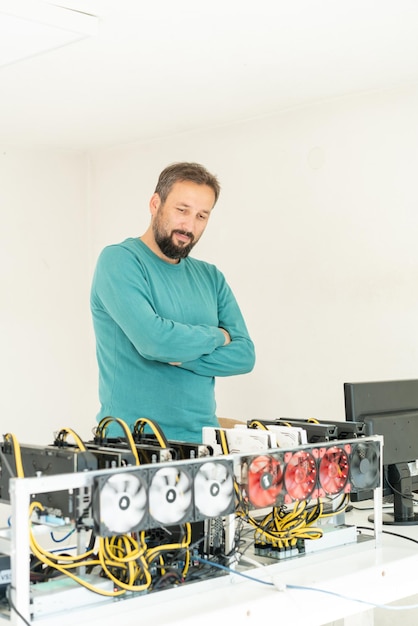 Junger Programmierer passt Kryptowährungs-Mining-Rig an optimale Betriebseinstellungen an. Foto in hoher Qualität