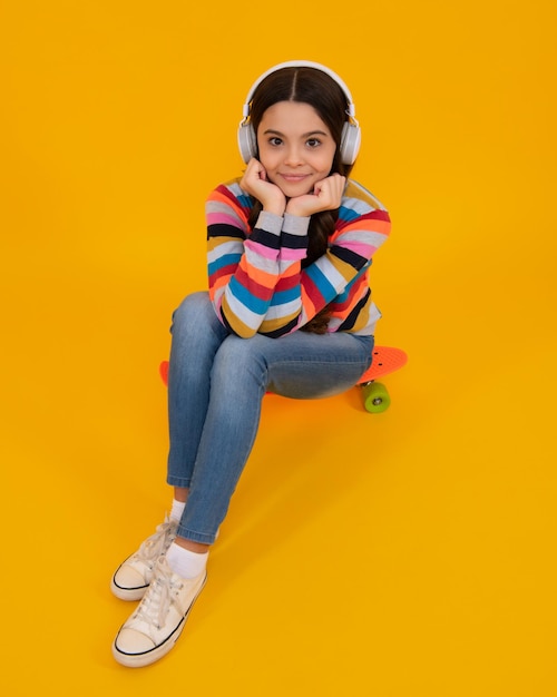 Kind hört Musik mit Kopfhörern Mädchen hört Lieder über drahtlose Kopfhörer Headset-Gerät Zubehör Stilvolles Teenager-Mädchen, das Musik hört Stylischer Hipster-Teenager im urbanen Kinderstil