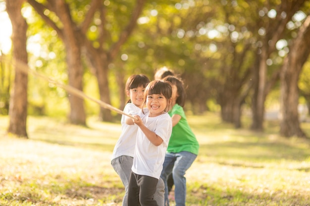 Foto kinder spielen tauziehen im park auf sunsut