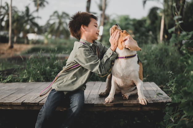 Foto kinder- und hundelebensstil im park. kleiner junge zusammen mit haustier als bester freund. outdoor-aktivität im sommerurlaub.