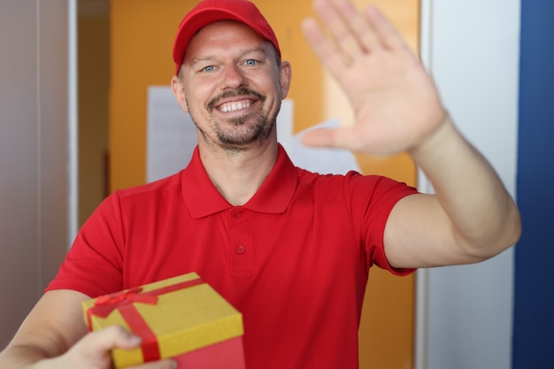 Kurier hält Hand und Geschenkbox zur Begrüßung.