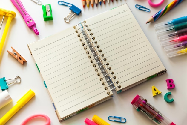 Leeres Notizbuch mit Büromaterial der Schule auf einem Schreibtisch mit Kopierraum