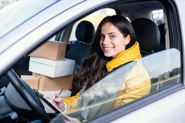 Lieferfrau im Auto mit Paket