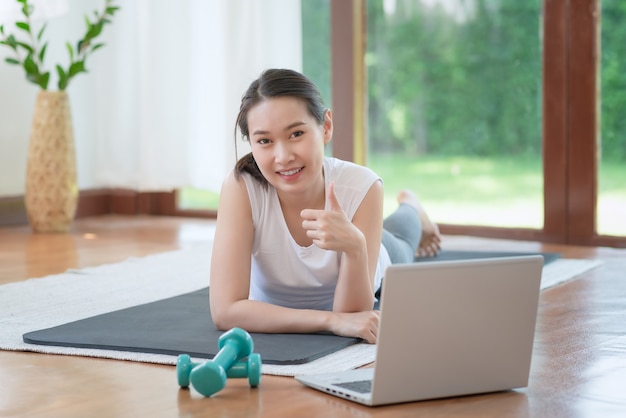 Linda mulher asiática se exercitando em casa para um estilo de vida saudável e moderno