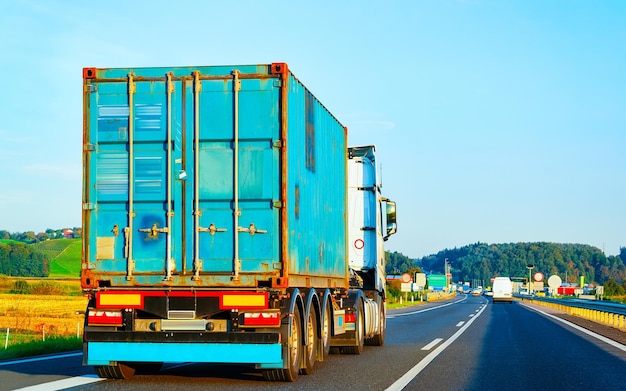 Foto lkw in der sommerstraße von polen. trucker auf der autobahn. lkw, der logistikarbeiten erledigt. auflieger mit fahrer. große frachtwagenfahrt. frachtversand. transport exportindustrie. container mit waren