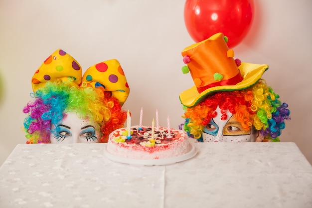 Foto lustige emotionale clowns auf der party können den kuchen nicht teilen