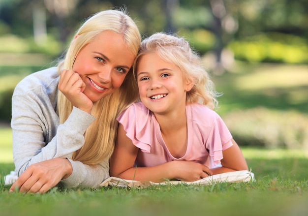 Mãe com a filha deitada no parque