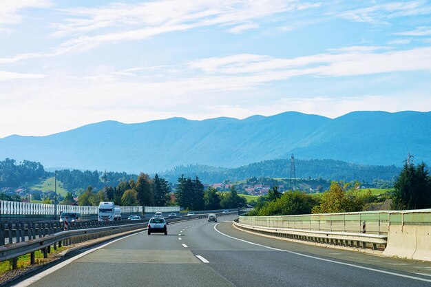 Foto malerische landschaft mit autos an der straße in slowenien. julische alpen im hintergrund.