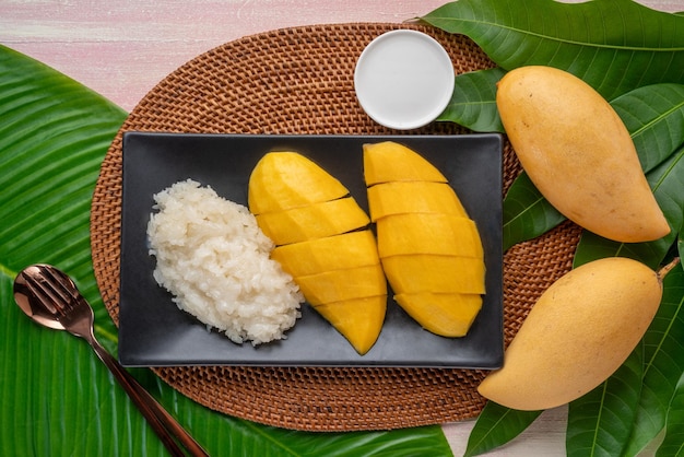 Manga com arroz pegajoso na chapa preta Manga amarela com leite pegajoso e de coco uma sobremesa tailandesa