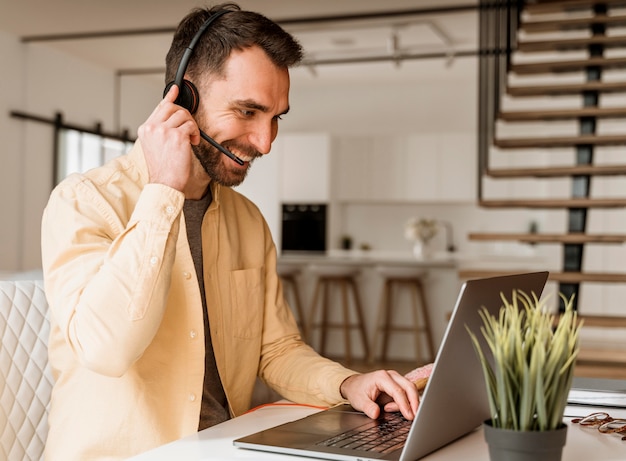 Mann mit Headset, der Videoanruf auf Laptop hat