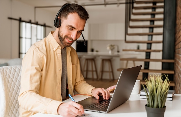 Mann mit Headset, der Videoanruf auf Laptop hat