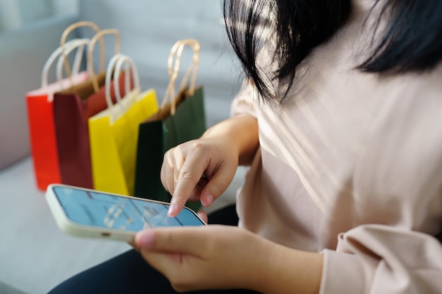 Foto mãos de mulher segurando telefone celular usando smartphone venda de sacos de compras conceito de estilo de vida de consumismo no shopping com saco de compras