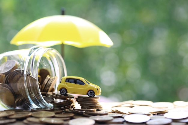 Foto miniatur-automodell auf wachsendem stapel von münzen geld auf grünem hintergrund der natur geld sparen für autofinanzierung und autokredit investitions- und geschäftskonzept