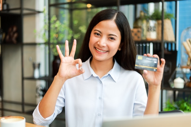 Mulher asiática usando cartão de crédito, compras on-line no café café