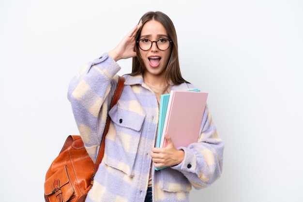 Mulher jovem estudante bonita isolada no fundo branco com expressão de surpresa