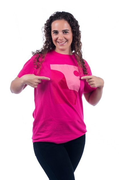 Foto mulher jovem positiva sorridente com camiseta rosa.