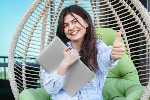 Mulher jovem satisfeita após um dia de trabalho com um laptop em uma rede