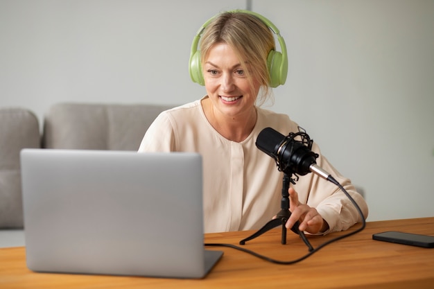 Mulher sorridente de tiro médio gravando podcast