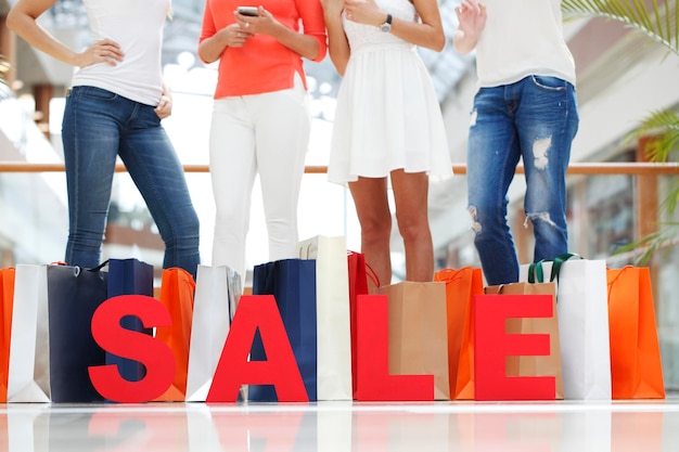 Foto mulheres com letras de venda vermelha no conceito de compras de shopping