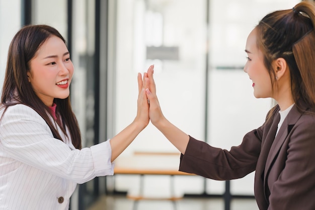 Foto mulheres de negócios asiáticas bem-sucedidas a celebrar com um 