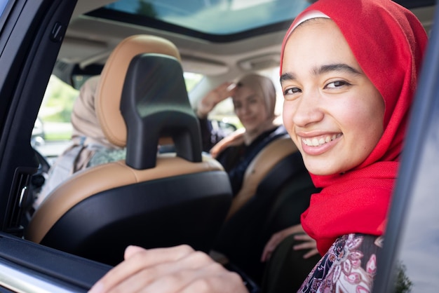 Muslimische Freundinnen genießen Roadtrip im Urlaub im Auto. Foto in hoher Qualität