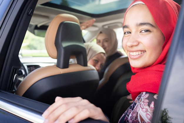 Muslimische Freundinnen genießen Roadtrip im Urlaub im Auto. Foto in hoher Qualität