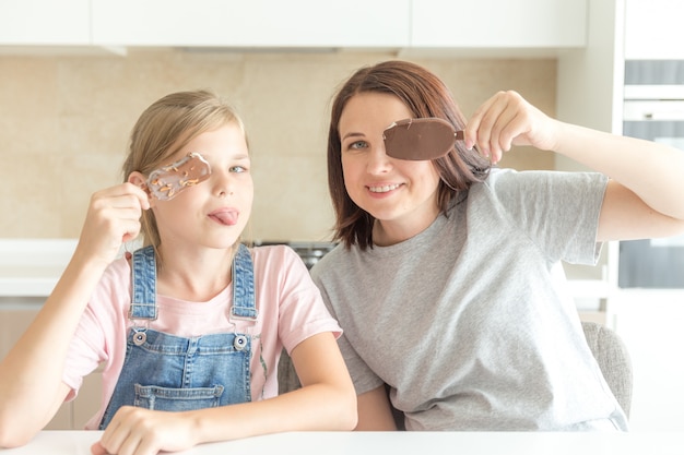 Foto mutter mit tochter in der küche eiscreme essend, gute beziehungen des elternteils und des kindes, glückliches familienkonzept