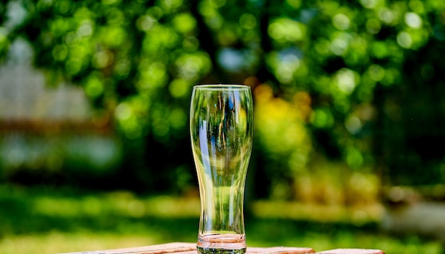 Nahaufnahmebild eines leeren Bierglases auf einem braunen Holztisch.