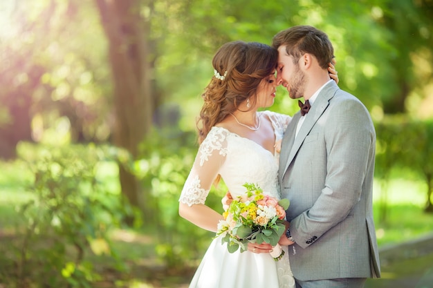 Noivo e noiva felizes em um parque no dia do casamento