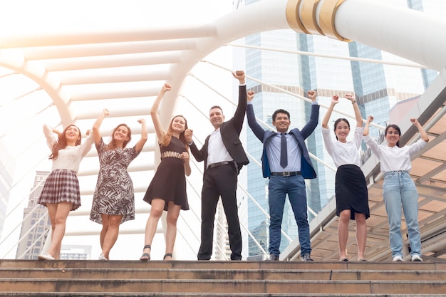 O grupo de equipe do negócio que guarda as mãos levantou o sucesso comercial.