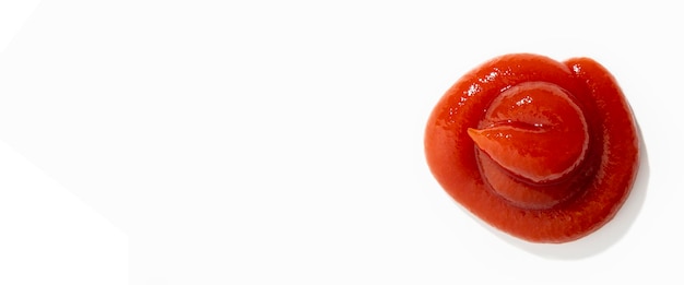 O molho vermelho de ketchup é derramado em um fundo branco Vista superior plana lay Banner