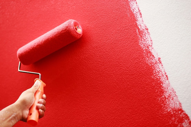 O pintor está pintando a parede interna de vermelho