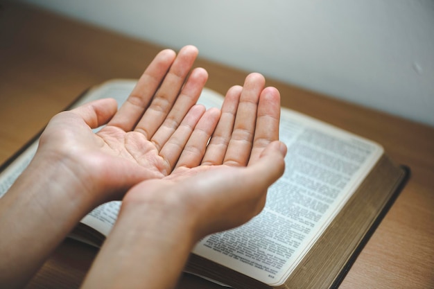 Foto oração com a mão em uma bíblia santa no conceito da igreja para a fé, espiritualidade e religião uma mulher orando na bíblia santa pela manhã mulher com a mão com a bíblia orando