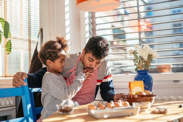 Pai e filha assando juntos na cozinha