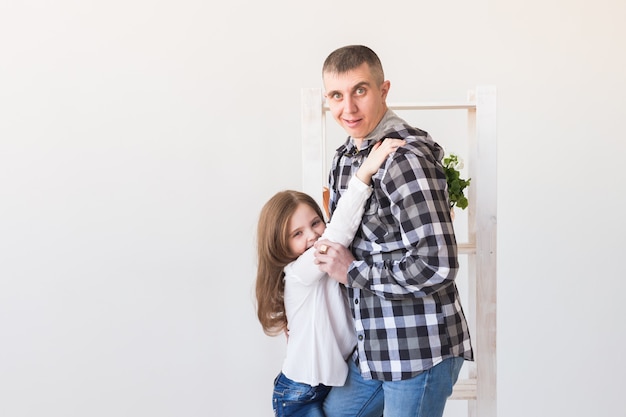 Pai engraçado está penteando sua filha e sorrindo enquanto eles estão juntos em