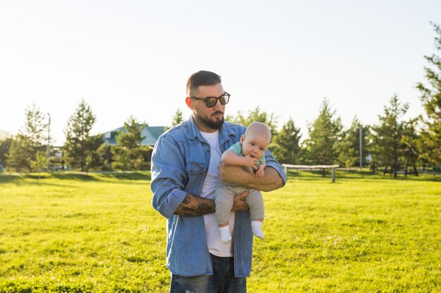 Pai feliz segurando filho bebê no conceito de natureza de família feliz dia dos pais e filho