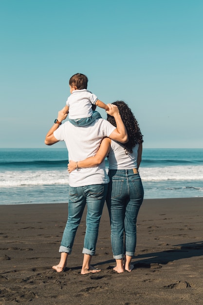 Pai, segurando, bebê, ligado, pescoço, e, abraçando, com, esposa, ligado, praia