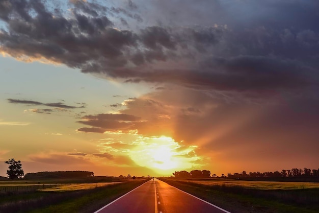 Paisagem com estrada e céu tempestuoso ao pôr do sol