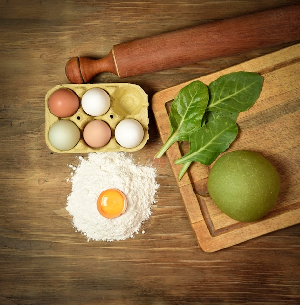 Pão de massa de macarrão verde com ingredientes na mesa