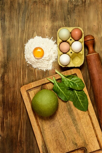 Pão de massa de macarrão verde com ingredientes na mesa