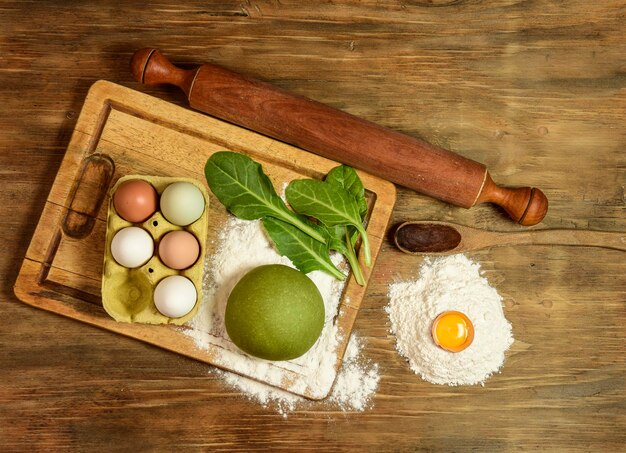 Pão de massa de macarrão verde com ingredientes na mesa