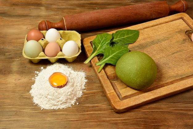 Pão de massa de macarrão verde com ingredientes na mesa