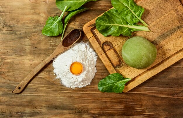 Pão de massa verde para macarrão com ingredientes na mesa