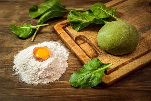 Pão de massa verde para macarrão com ingredientes na mesa