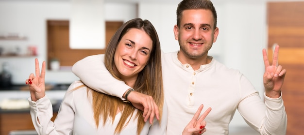 Par, em, dia valentine, sorrindo, e, mostrando, sinal vitória, em, um, casa